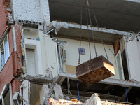 A crane and container are being used to remove the rubble at the apartment block hit by a Russian missile in Dnipro, Ukraine, on June 30, 20...