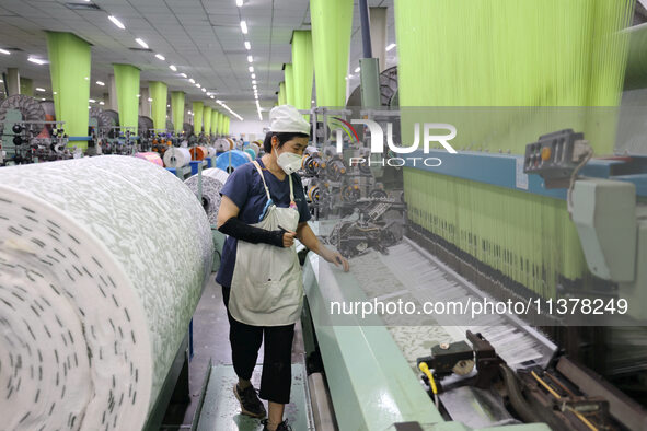 Workers are producing towel products for export at a workshop of a towel manufacturer in Binzhou, China, on July 2, 2024. 