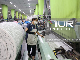 Workers are producing towel products for export at a workshop of a towel manufacturer in Binzhou, China, on July 2, 2024. (