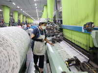 Workers are producing towel products for export at a workshop of a towel manufacturer in Binzhou, China, on July 2, 2024. (