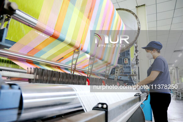 Workers are producing towel products for export at a workshop of a towel manufacturer in Binzhou, China, on July 2, 2024. 