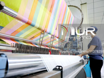 Workers are producing towel products for export at a workshop of a towel manufacturer in Binzhou, China, on July 2, 2024. (