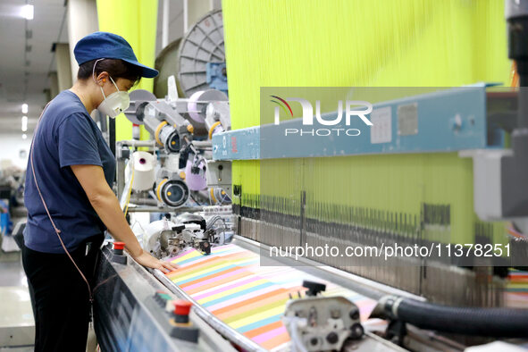 Workers are producing towel products for export at a workshop of a towel manufacturer in Binzhou, China, on July 2, 2024. 