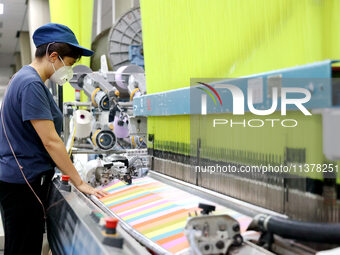 Workers are producing towel products for export at a workshop of a towel manufacturer in Binzhou, China, on July 2, 2024. (