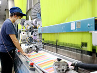 Workers are producing towel products for export at a workshop of a towel manufacturer in Binzhou, China, on July 2, 2024. (