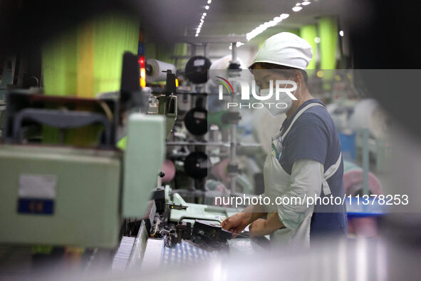 Workers are producing towel products for export at a workshop of a towel manufacturer in Binzhou, China, on July 2, 2024. 