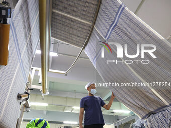 Workers are producing towel products for export at a workshop of a towel manufacturer in Binzhou, China, on July 2, 2024. (