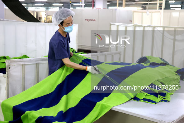 Workers are producing towel products for export at a workshop of a towel manufacturer in Binzhou, China, on July 2, 2024. 