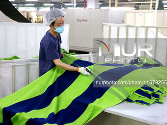 Workers are producing towel products for export at a workshop of a towel manufacturer in Binzhou, China, on July 2, 2024. (