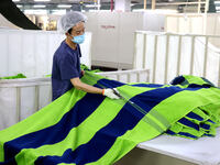 Workers are producing towel products for export at a workshop of a towel manufacturer in Binzhou, China, on July 2, 2024. (