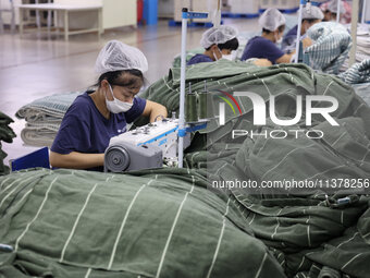 Workers are producing towel products for export at a workshop of a towel manufacturer in Binzhou, China, on July 2, 2024. (