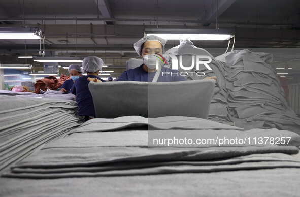 Workers are producing towel products for export at a workshop of a towel manufacturer in Binzhou, China, on July 2, 2024. 