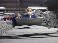 Workers are producing towel products for export at a workshop of a towel manufacturer in Binzhou, China, on July 2, 2024. (