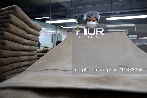 Workers are producing towel products for export at a workshop of a towel manufacturer in Binzhou, China, on July 2, 2024. 