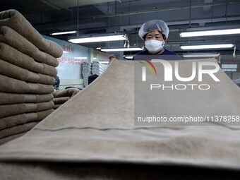 Workers are producing towel products for export at a workshop of a towel manufacturer in Binzhou, China, on July 2, 2024. (