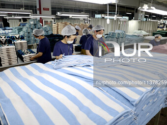 Workers are producing towel products for export at a workshop of a towel manufacturer in Binzhou, China, on July 2, 2024. (