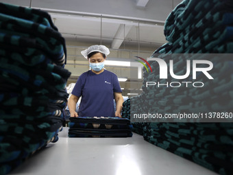 Workers are producing towel products for export at a workshop of a towel manufacturer in Binzhou, China, on July 2, 2024. (