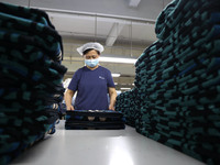 Workers are producing towel products for export at a workshop of a towel manufacturer in Binzhou, China, on July 2, 2024. (