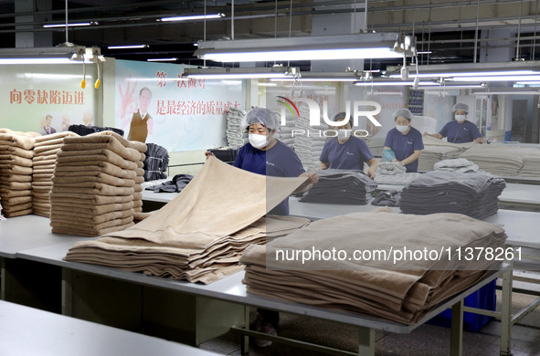 Workers are producing towel products for export at a workshop of a towel manufacturer in Binzhou, China, on July 2, 2024. 