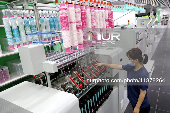 Workers are producing towel products for export at a workshop of a towel manufacturer in Binzhou, China, on July 2, 2024. 