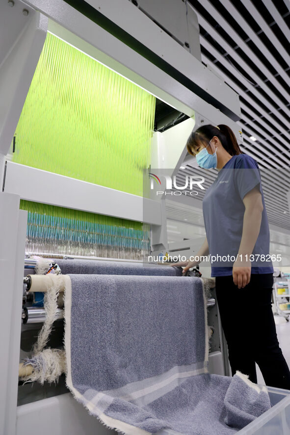 Workers are producing towel products for export at a workshop of a towel manufacturer in Binzhou, China, on July 2, 2024. 