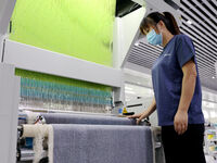 Workers are producing towel products for export at a workshop of a towel manufacturer in Binzhou, China, on July 2, 2024. (