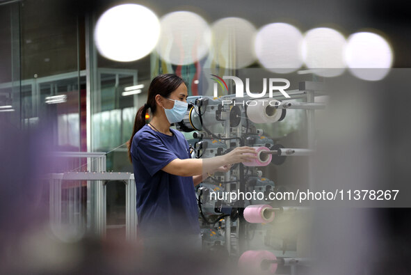 Workers are producing towel products for export at a workshop of a towel manufacturer in Binzhou, China, on July 2, 2024. 