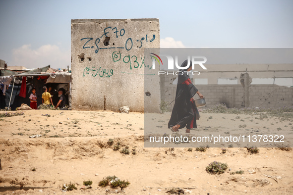 A Palestinian girl is walking in the street in Deir el-Balah in the central Gaza Strip on July 2, 2024, amid the ongoing conflict in the Pal...