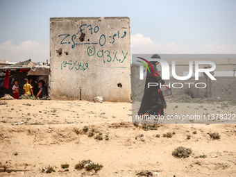 A Palestinian girl is walking in the street in Deir el-Balah in the central Gaza Strip on July 2, 2024, amid the ongoing conflict in the Pal...