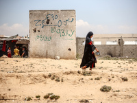 A Palestinian girl is walking in the street in Deir el-Balah in the central Gaza Strip on July 2, 2024, amid the ongoing conflict in the Pal...