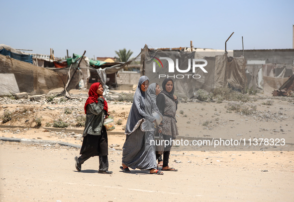 Palestinian women are walking in the street in Deir el-Balah in the central Gaza Strip on July 2, 2024, amid the ongoing conflict in the Pal...