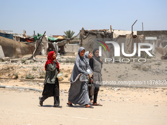 Palestinian women are walking in the street in Deir el-Balah in the central Gaza Strip on July 2, 2024, amid the ongoing conflict in the Pal...