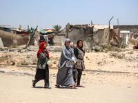 Palestinian women are walking in the street in Deir el-Balah in the central Gaza Strip on July 2, 2024, amid the ongoing conflict in the Pal...