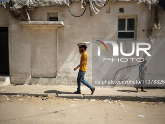 A Palestinian seller is carrying sweets as he is walking in Deir el-Balah in the central Gaza Strip on July 2, 2024, amid the ongoing confli...