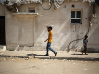 A Palestinian seller is carrying sweets as he is walking in Deir el-Balah in the central Gaza Strip on July 2, 2024, amid the ongoing confli...