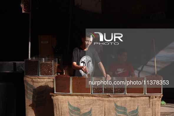 A coffee merchant is manning his stall by whole and ground coffee beans at a shop in Deir el-Balah in the central Gaza Strip on July 2, 2024...