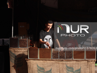 A coffee merchant is manning his stall by whole and ground coffee beans at a shop in Deir el-Balah in the central Gaza Strip on July 2, 2024...