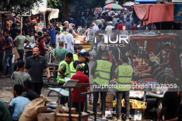 People are walking along a crowded market street in Deir el-Balah in the central Gaza Strip on July 2, 2024, amid the ongoing conflict in th...