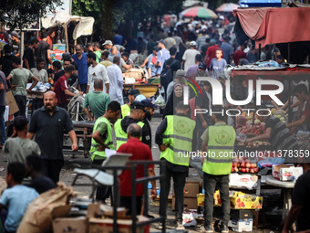 People are walking along a crowded market street in Deir el-Balah in the central Gaza Strip on July 2, 2024, amid the ongoing conflict in th...