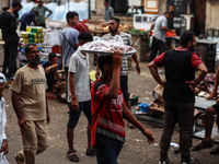 People are walking along a crowded market street in Deir el-Balah in the central Gaza Strip on July 2, 2024, amid the ongoing conflict in th...