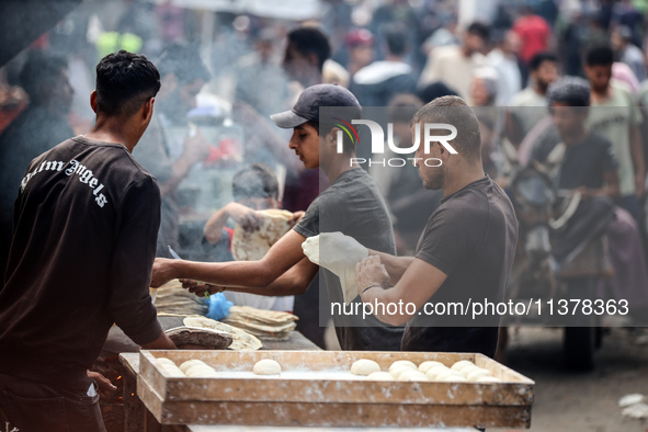 People are walking along a crowded market street in Deir el-Balah in the central Gaza Strip on July 2, 2024, amid the ongoing conflict in th...