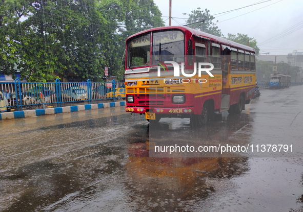 A minibus is running on the street in rainy weather in Kolkata, India, on July 2, 2024. 