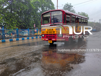 A minibus is running on the street in rainy weather in Kolkata, India, on July 2, 2024. (