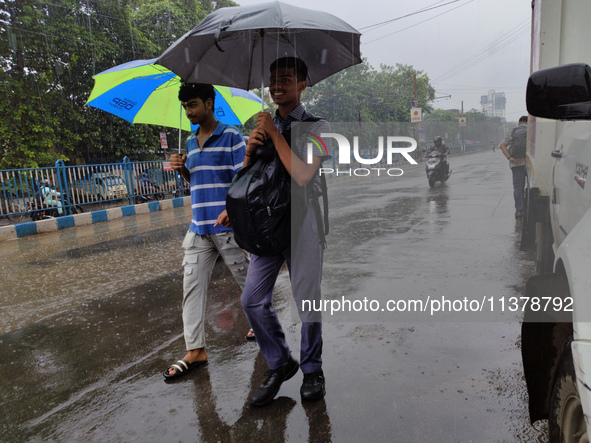 People are walking on the street in rainy weather in Kolkata, India, on July 2, 2024. 