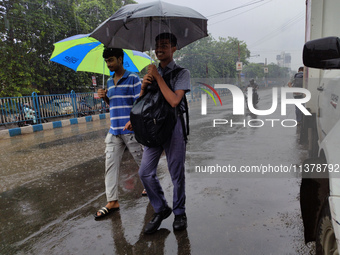 People are walking on the street in rainy weather in Kolkata, India, on July 2, 2024. (