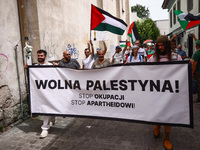 People hold  'Free Palestine'  banner attending solidarity with Palestine demonstration at Kazimierz, the Jewish historic district in Krakow...