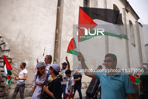 People attend solidarity with Palestine demonstration marching in Kazimierz, the Jewish historic district in Krakow, Poland on June 30, 2024...