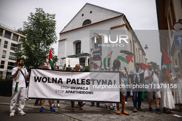 People hold 'Free Palestine' banner while attending solidarity with Palestine demonstration at Kazimierz, the Jewish historic district in Kr...