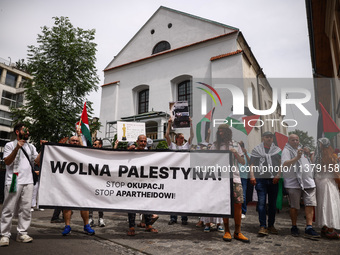 People hold 'Free Palestine' banner while attending solidarity with Palestine demonstration at Kazimierz, the Jewish historic district in Kr...