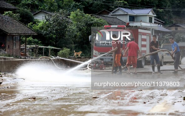 Firefighters are washing a road in Si 'an village, Rongan county, Liuzhou city, South China's Guangxi Zhuang Autonomous region, in Liuzhou,...